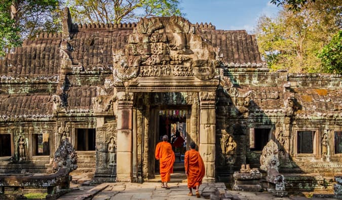 在柬埔寨的一座寺庙里，两名身穿橙色僧袍的僧侣行走