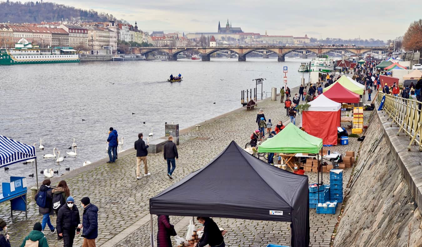 Menschen zu Fuß in der Nähe von Ständen entlang des Flusses in Prag, Tschechien