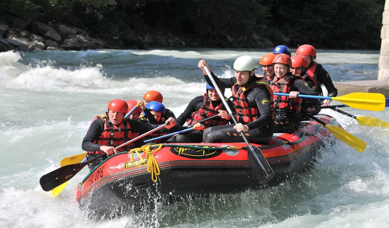 group of people going down river rapids in a raft